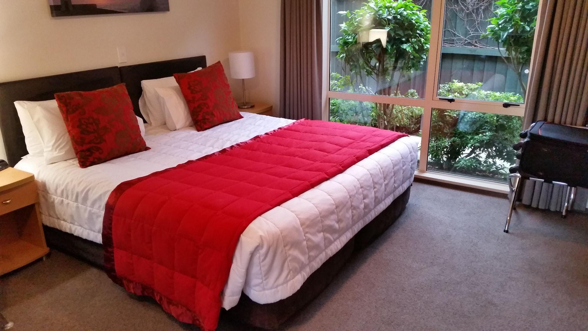 Colombo In The City Крайстчърч Екстериор снимка A bed with a red throw
